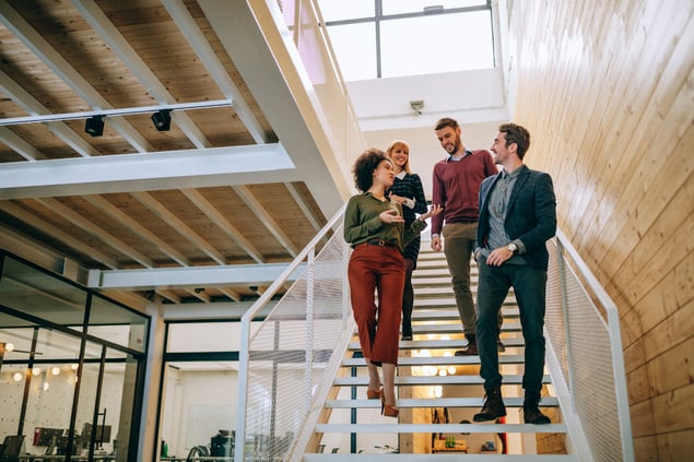 Four co-workers walking in an office together