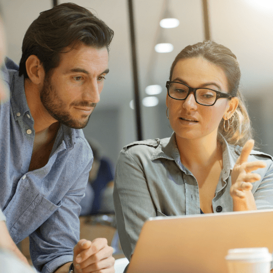 Image of a man and woman looking down at a laptop