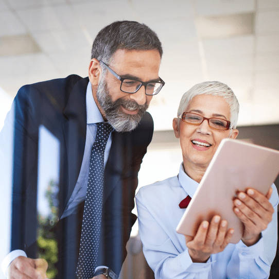 A man and a woman looking at a tablet