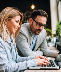 Two finance professionals working alongside each other on a laptop