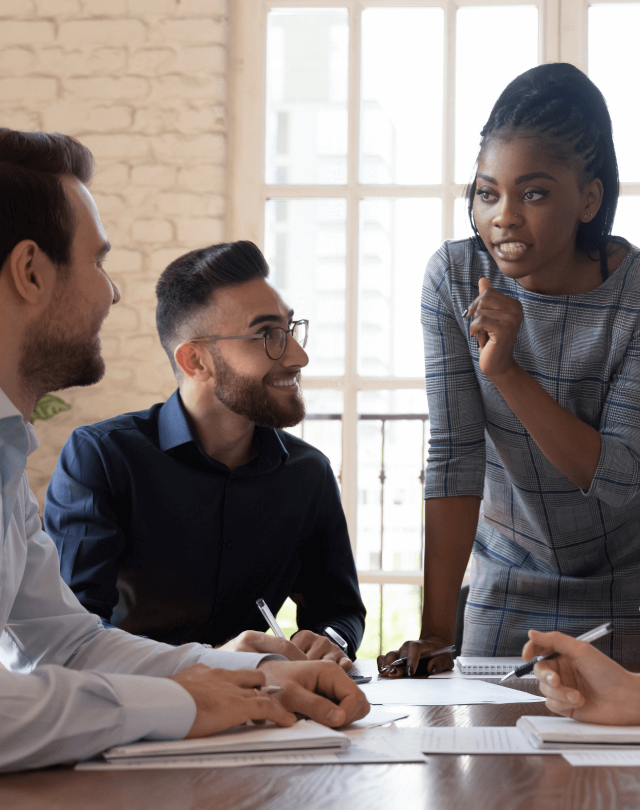 Black female business executive speaking with her colleagues.