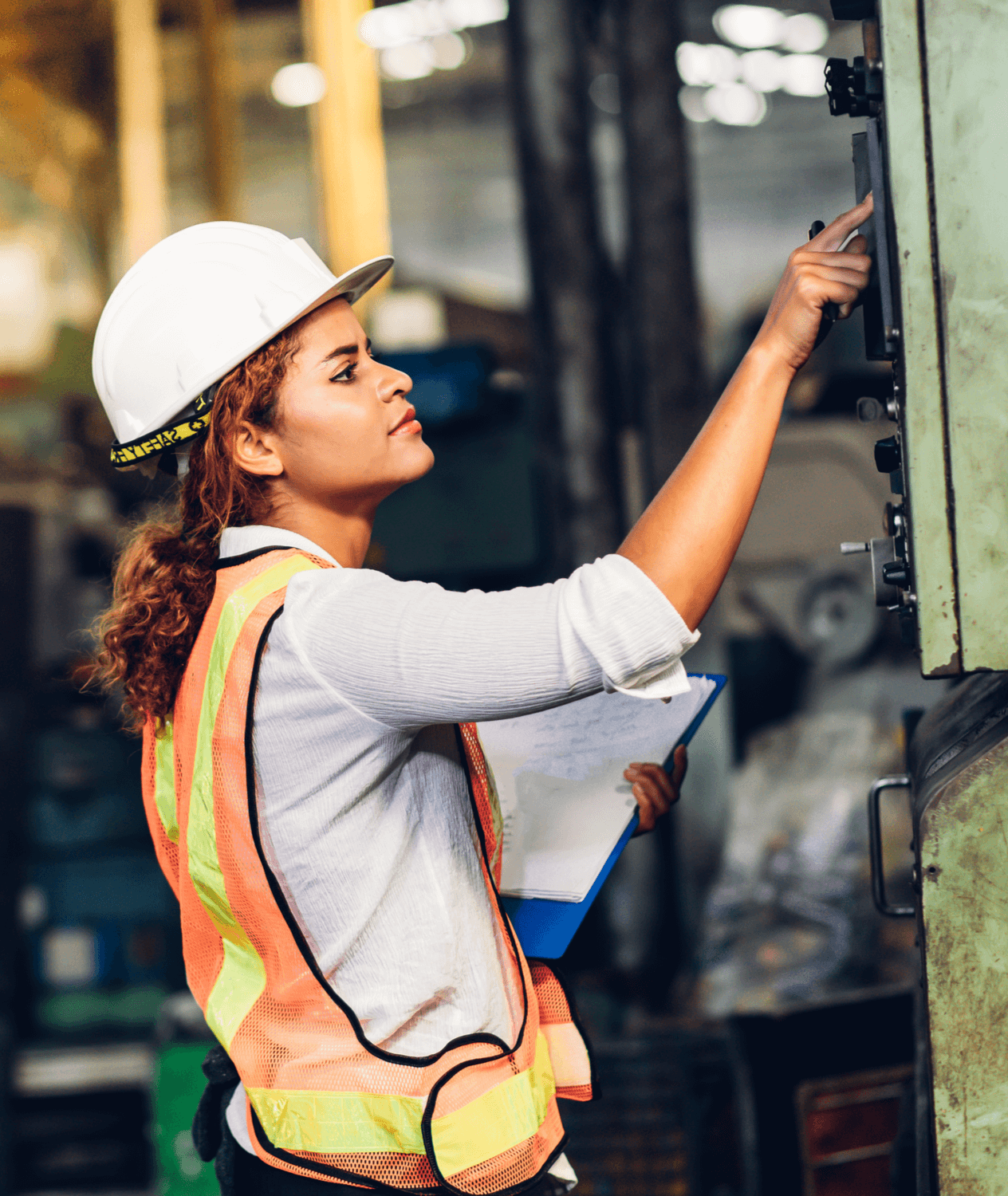 Female engineer pressing buttons on an electrical panel in a factory.