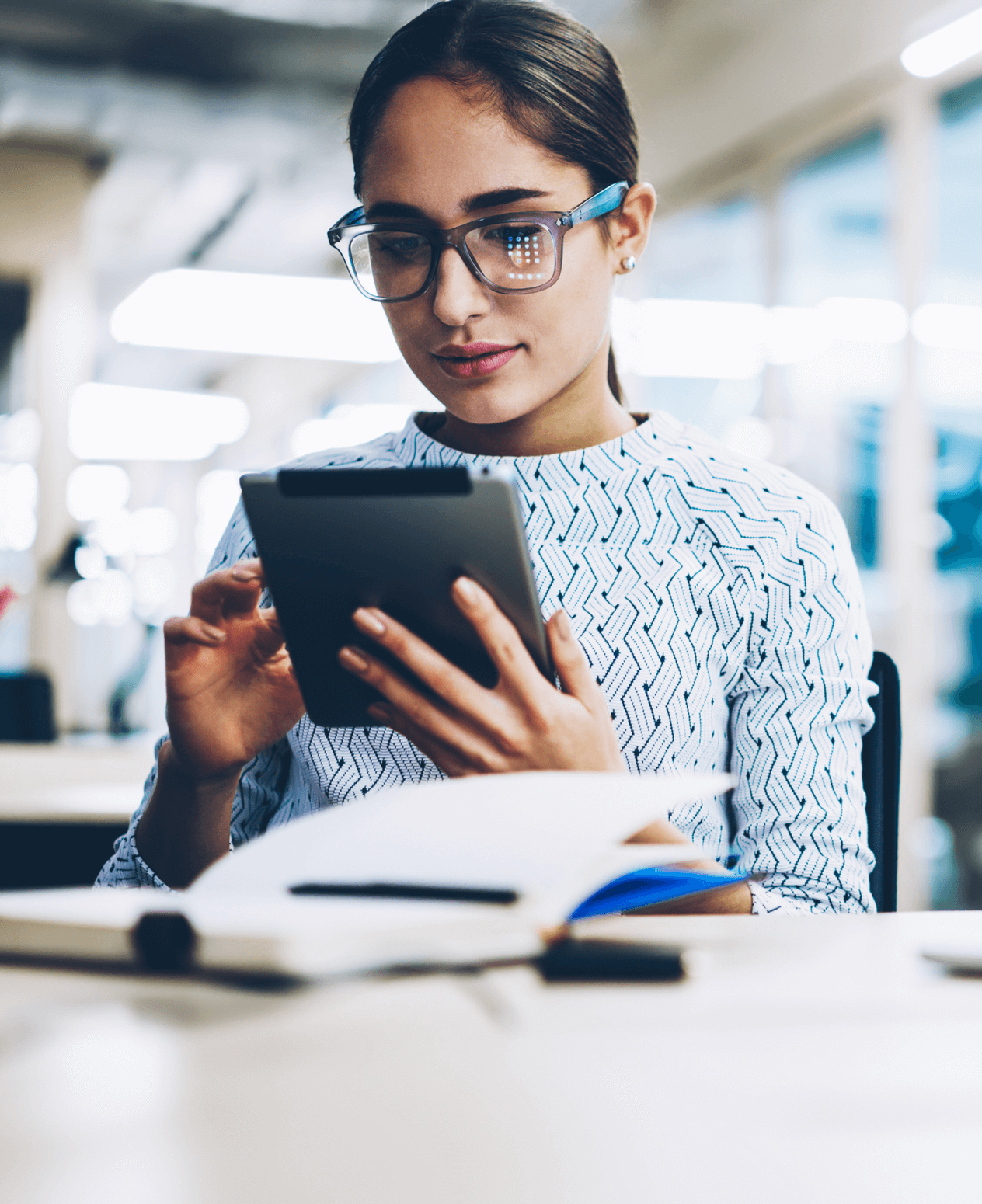 Young woman working on a tablet in a library.