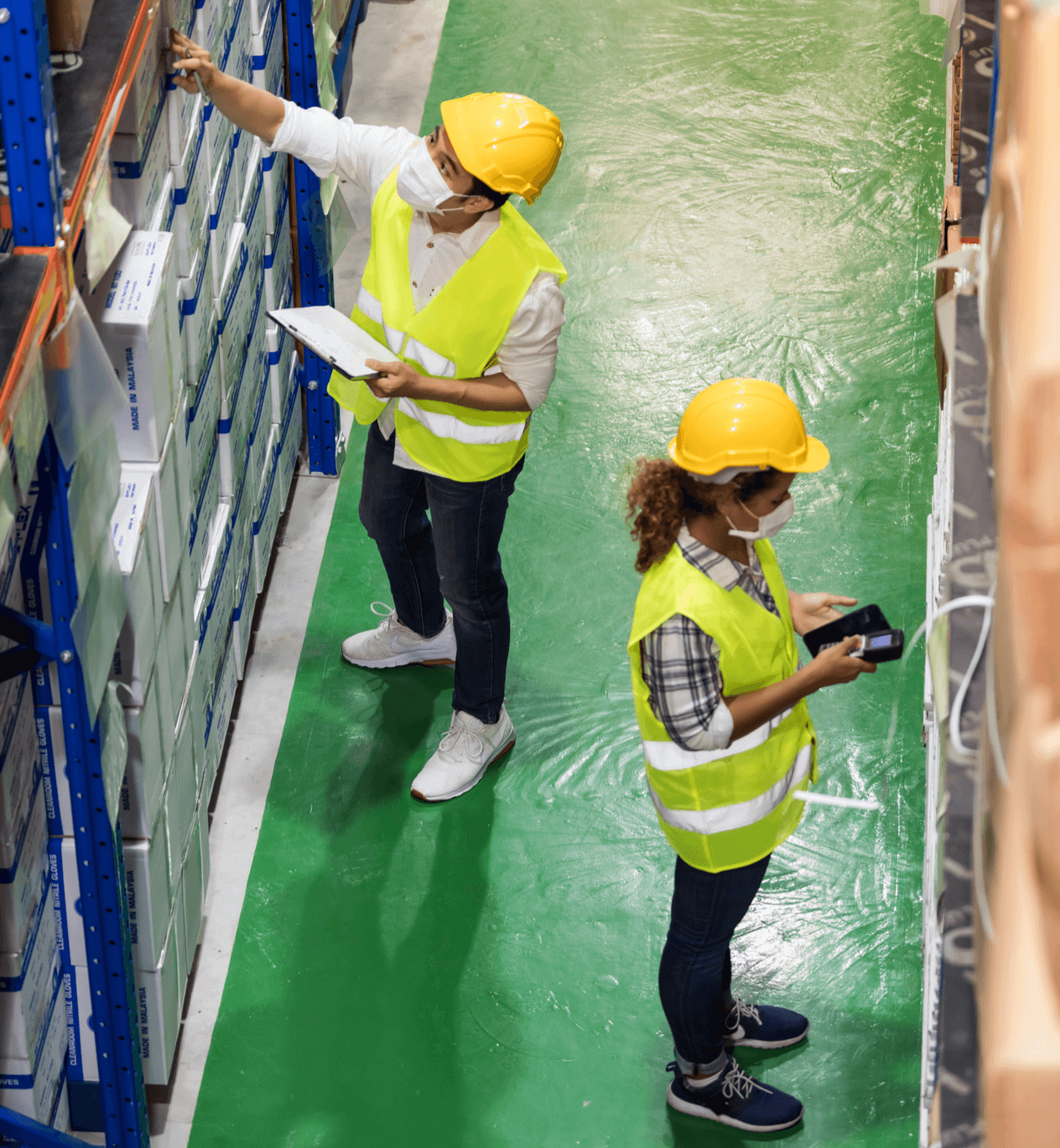 Birds eye view of two warehouse workers checking stock.