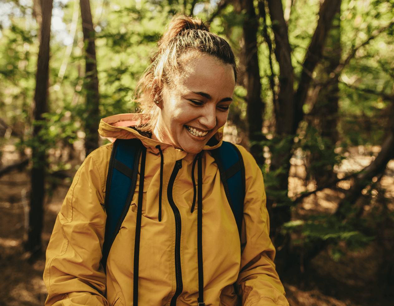 Smiling woman walking in the forest.