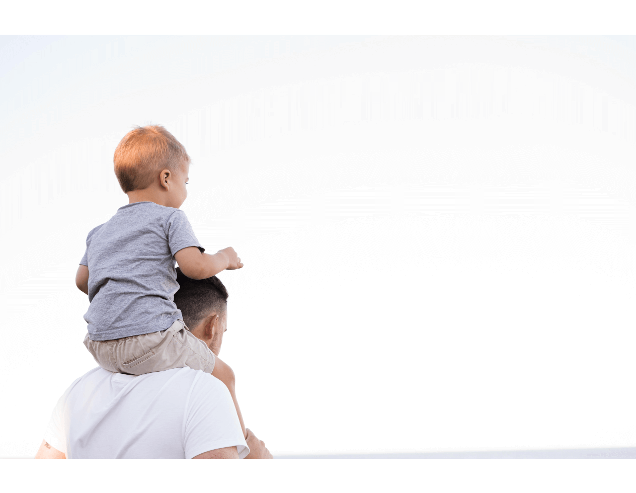 Man with son on his shoulders on a white background.