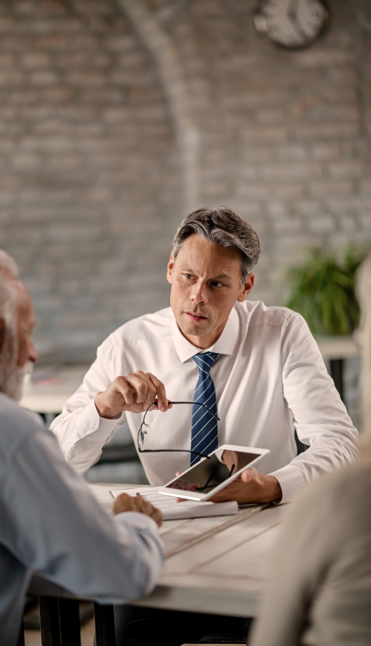 One person showing a tablet to another person