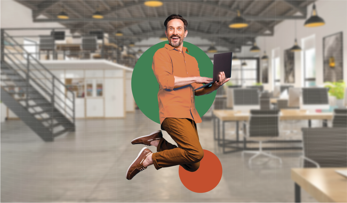 Smiling man jumping with laptop in hand.