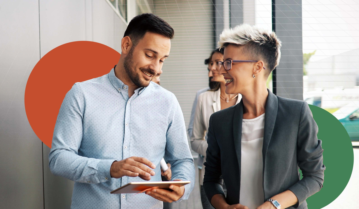 Finance teammates working from a device share a laugh