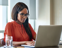 Image of a woman sitting at a desk on a laptop