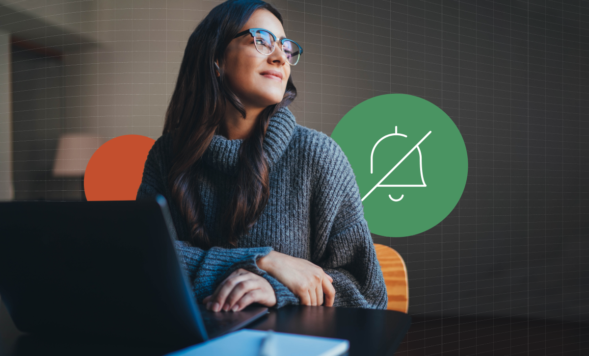 Woman in finance looking away from her laptop with a notifications off icon in the background.