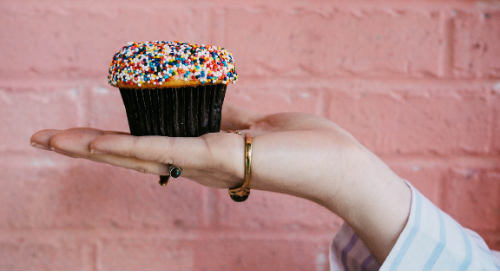 Woman's hand holding a cupcake.
