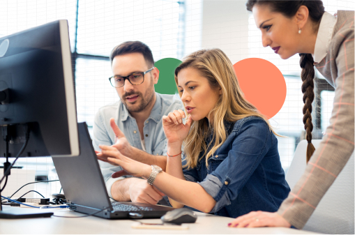 Three co-workers working together in front of a computer