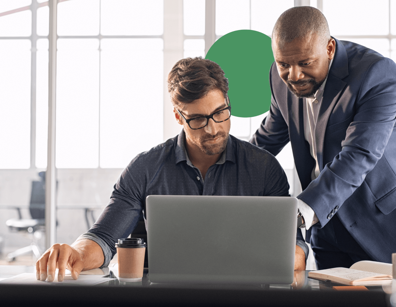 Branded image of two co-workers looking at a laptop screen.