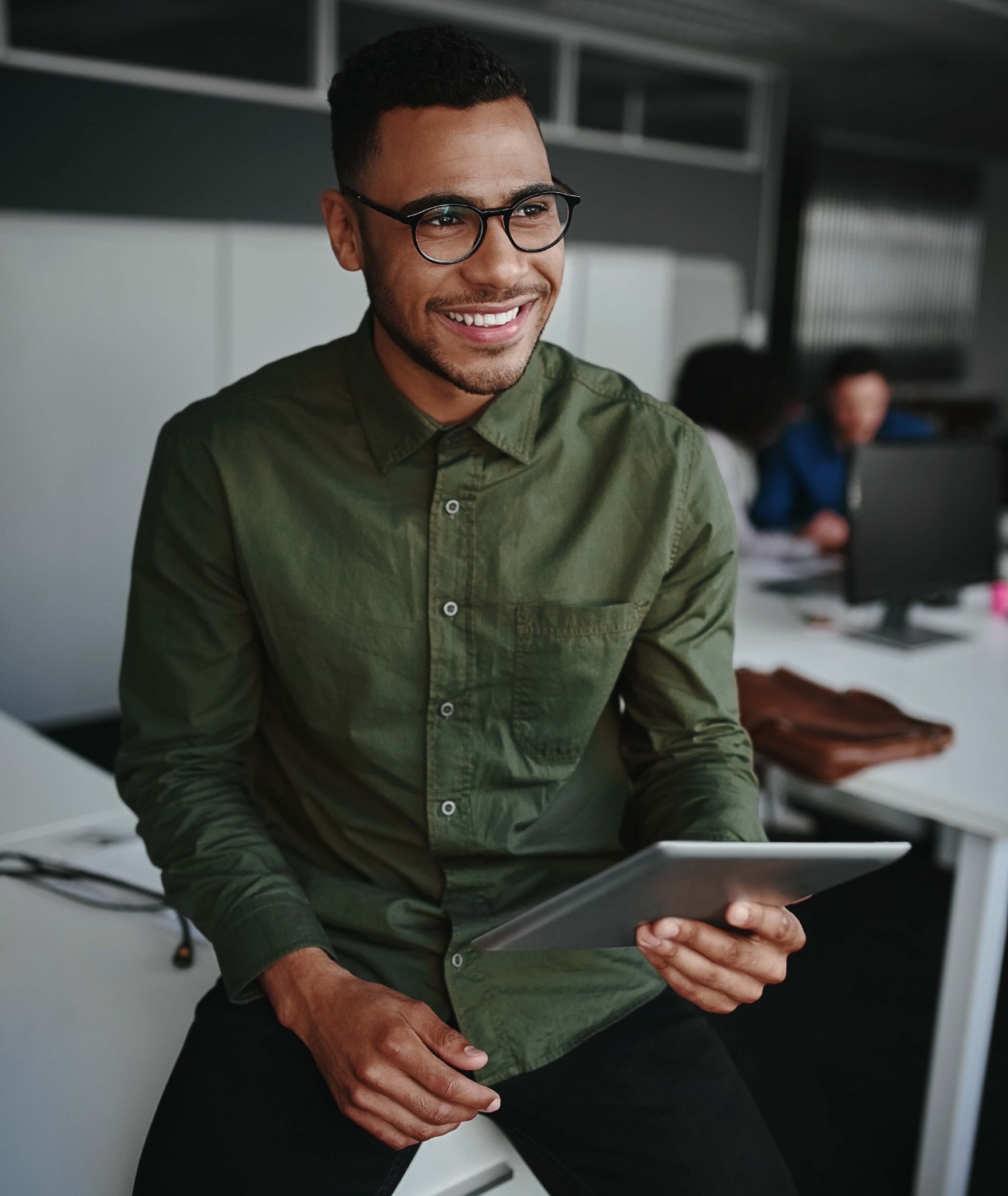 A person sitting and holding a tablet