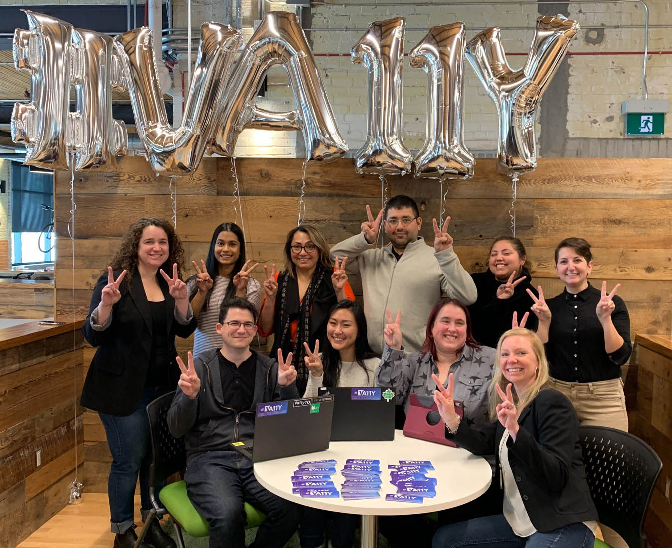 Some of the members of the va11y team, showing our love for accessibility with balloons and stickers during an event held in our office.