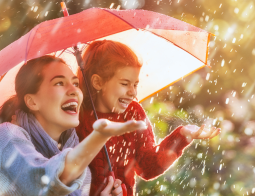 Image of a mother and daughter under an umbrella in the rain
