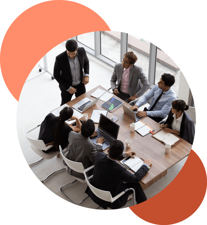 A birds eye view of people collaborating around a desk in an office A birds eye view of people collaborating around a desk in an office
