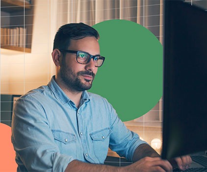Man sitting at desk, working on his computer.